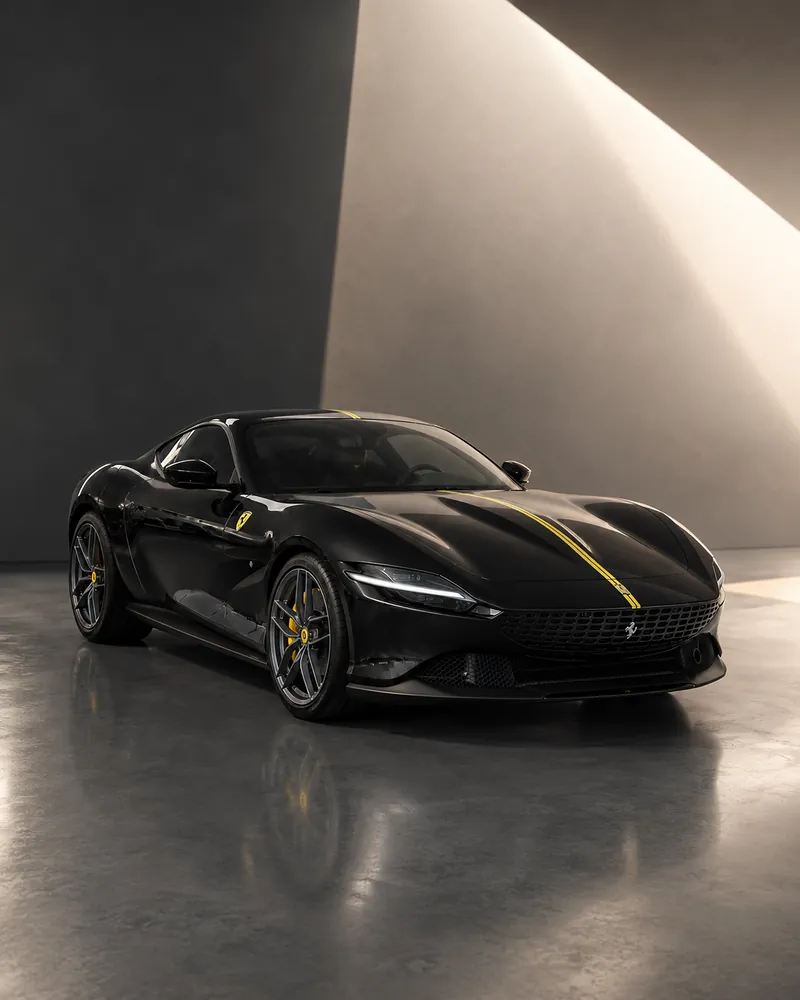 Ferrari Roma nera in una sala di cemento attraversata da una lama di luce